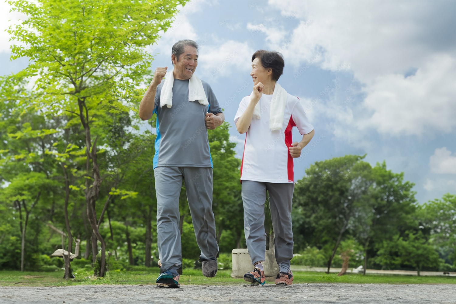 笑顔で散歩する高齢男性と女性。日々のケアが元気の秘訣